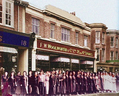 A rare, early colour photograph, taking in the early morning in Spring 1937, showing the assembled staff of the large F.W. Woolworth store in London Road, Bognor Regis, West Sussex. The store could boast such a large team that standing shoulder to shoulder they stood almost ten metres wider than the frontage. The picture was taken from across the other side of the street in bright early morning sunlight by the new General Manager, Philip Picot