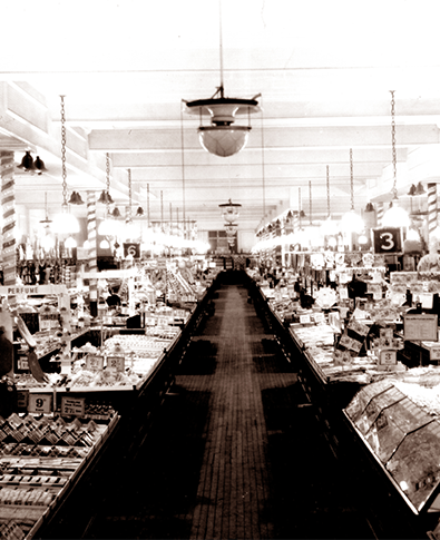 The salesfloors of F.W. Woolworth's seaside stores had a very distinctive look in the late 1940s, blending features of pre-war times like the mahogany counters and oiled pitched pine floors, with modern innovations like the glass and transparent plastic personal service weigh-out sweets (pic and mix) counter in the front foreground and specialists stands for more expensive lines like branded perfumes. Considering that many items were still rationed, the counters in this pre-Christmas shot taken in 1947 are surprisingly full with few if any references to coupons, but a number of price tickets showing ten shillings or more, ten times the pre-war maximum.