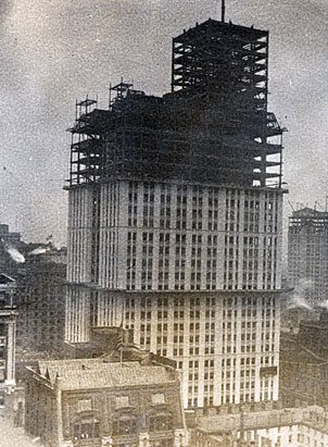 The spire of the Woolworth Building rises from the streets of Manhattan as building work continues